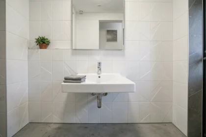 Salle de bain moderne avec dalles PVC murales blanches effet relief et vasque en céramique
